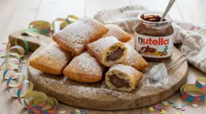 Bugie di Carnevale ripiene di Nutella su un tagliere con zucchero a velo e coriandoli colorati