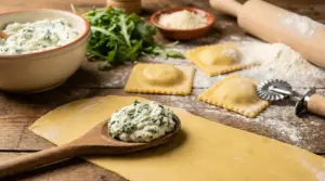 Ripieno cremoso di ricotta e spinaci su cucchiaio di legno accanto a ravioli freschi fatti in casa